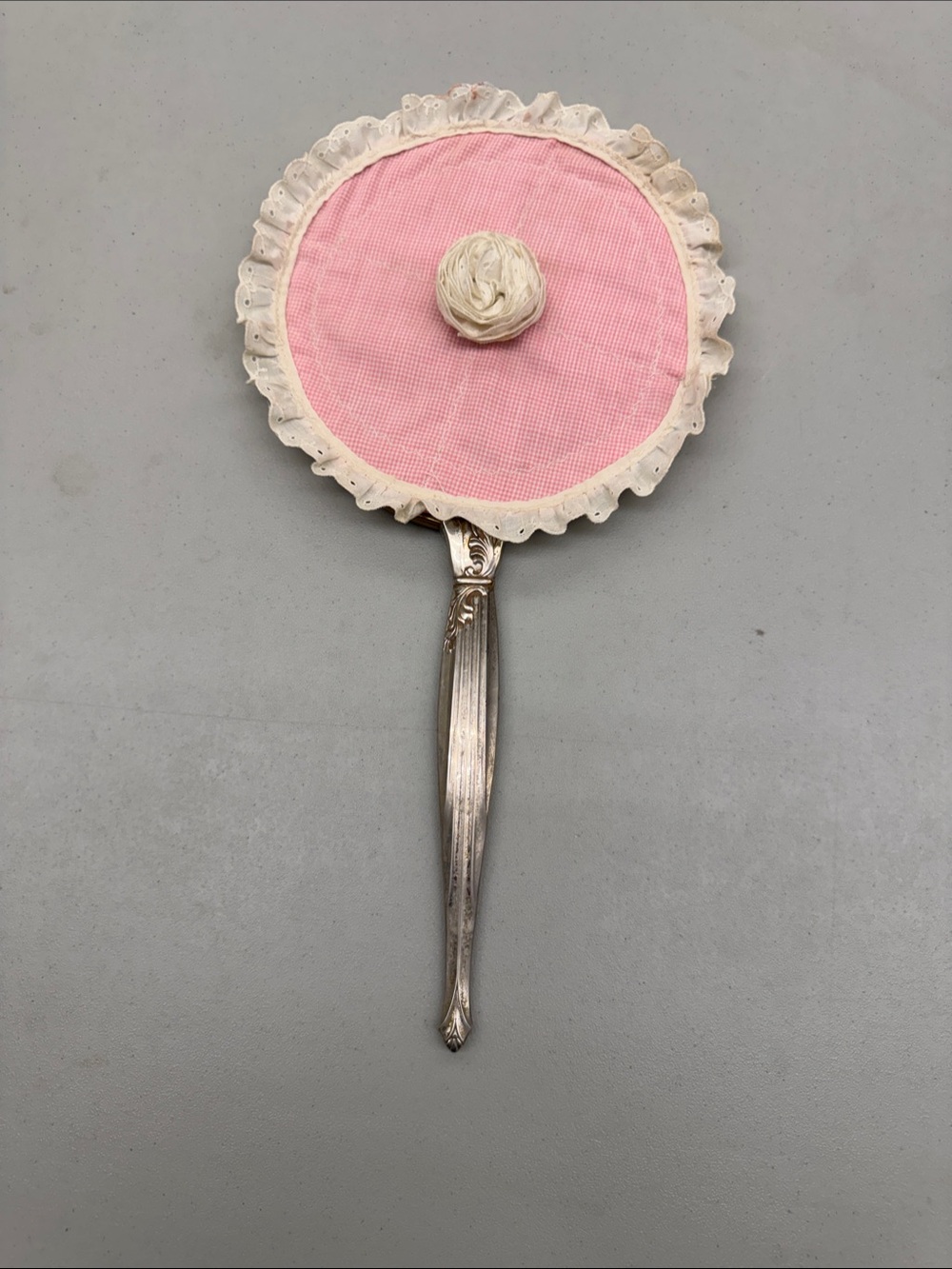 Vintage handheld vanity mirror featuring an ornate gold-silver handle fabric trm